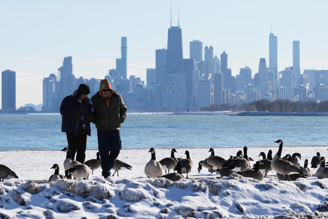 People bundle up as they take a walk during a cold weather day in the snow-covered at Lake Michigan in Chicago, Thursday, December 4, 2025. (Photo by Nam Y. Huh/AP Photo)