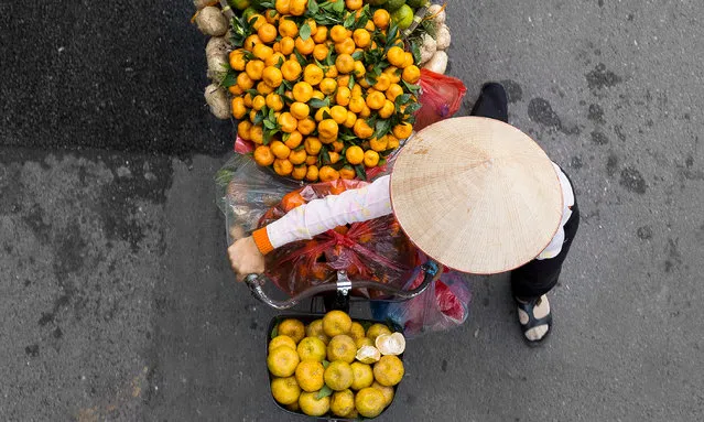 Photographer Loes Heerink spent hours waiting on bridges in Hanoi to capture the street vendors who walked underneath. She recently launched a Kickstarter project to publish a book of these images. Here: “In Hanoi there are a lot of street vendors who roam the city with their bicycles trying to sell goods, from vegetables to flowers”. (Photo by Loes Heerink/The Guardian)