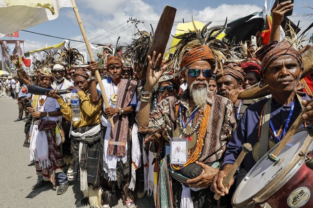 Catholic faithful wait on a street to welcome Pope Francis in Dili on September 9, 2024. Catholic devotees were clamouring to see Pope Francis before his arrival in East Timor's capital on September 9 – making pilgrimages from faraway towns and hours-long crossings of its shared border with Indonesia. (Photo by Yasuyoshi Chiba/AFP Photo)