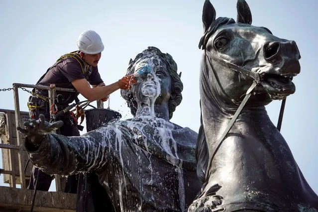 A worker washes a city landmark, the equestrian statue of Peter the Great known as the Bronze Horseman by French sculptor Etienne Maurice Falconet, in St. Petersburg, Russia, Friday, May 26, 2023. (Photo by Dmitri Lovetsky/AP Photo)