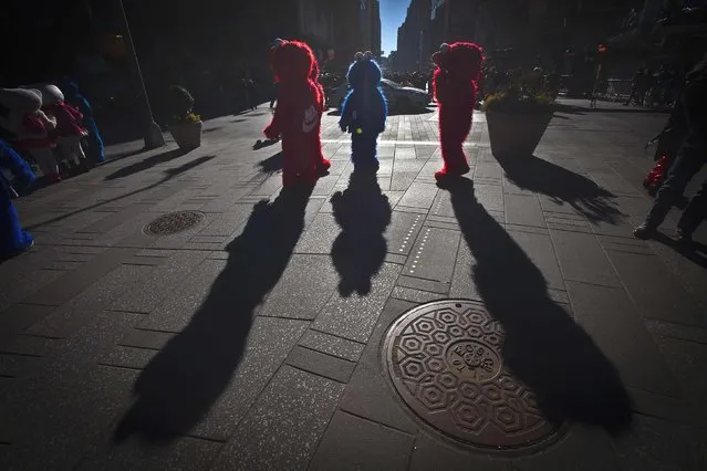 A group of costume characters who pose in photos for tips stand in the sunlight in Times Square in the Manhattan borough of New York January 17, 2015. (Photo by Carlo Allegri/Reuters)