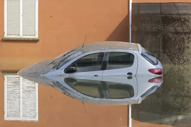 A car is submerged in Faenza, Italy, Thursday, May 18, 2023. Exceptional rains Wednesday in a drought-struck region of northern Italy swelled rivers over their banks, killing at least eight people, forcing the evacuation of thousands and prompting officials to warn that Italy needs a national plan to combat climate change-induced flooding. (Photo by Luca Bruno/AP Photo)