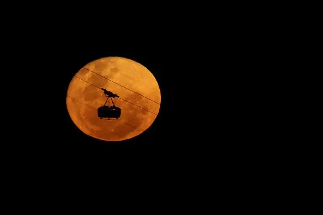 A cable car of the Pao de Acucar Mountain (Sugar Loaf Mountain) is seen passing in front of the Strawberry Moon, in Rio de Janeiro, Brazil on June 4, 2023. (Photo by Pilar Olivares/Reuters)