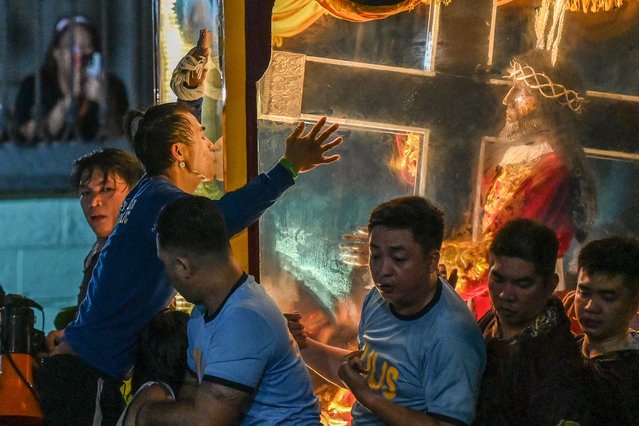 A Catholic devotee kisses the carriage during the annual religious procession of the Black Nazarene in Manila on January 9, 2025. Hundreds of thousands of Catholic pilgrims swarmed the streets of Manila in search of a miracle on January 9, straining to reach a centuries-old statue of Jesus Christ in an annual display of religious fervour. (Photo by Jam Sta Rosa/AFP Photo)