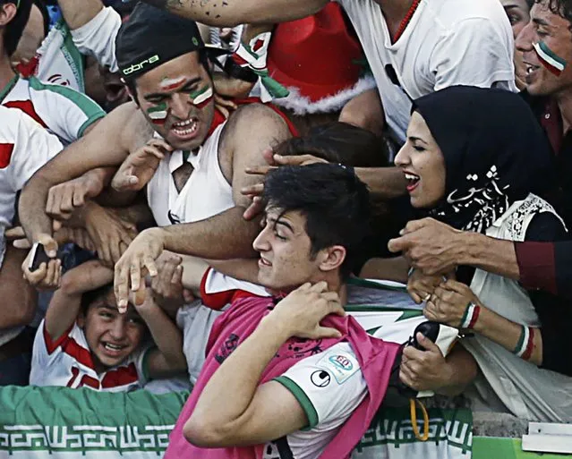 Iran's Sardar Azmoun has his jersey tugged as fans celebrate Iran's Morteza Pouraliganji's goal during their Asian Cup quarter-final soccer match against Iraq at the Canberra stadium in Canberra January 23, 2015. (Photo by Tim Wimborne/Reuters)