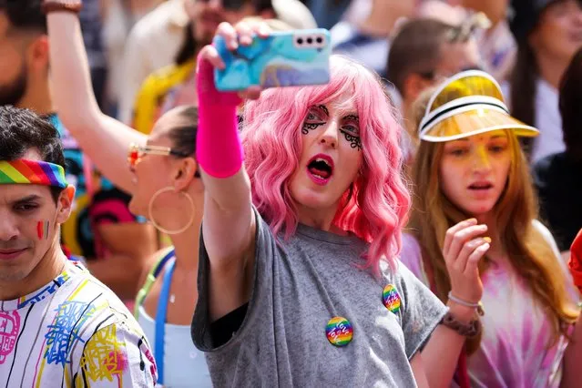 A participant holds the phone during the annual Belgian LGBT Pride Parade in central Brussels on May 21, 2023. (Photo by Johanna Geron/Reuters)