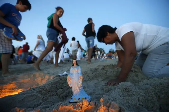 Devotees of the Afro-Brazilian goddess of the sea Lemanja pay tribute on Lemanja's Day at Ramirez beach in Montevideo February 2, 2015. (Photo by Andres Stapff/Reuters)