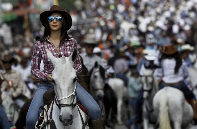 A woman takes part in a traditional horse parade through the streets of San Jose, Costa Rica December 26, 2015. (Photo by Juan Carlos Ulate/Reuters)