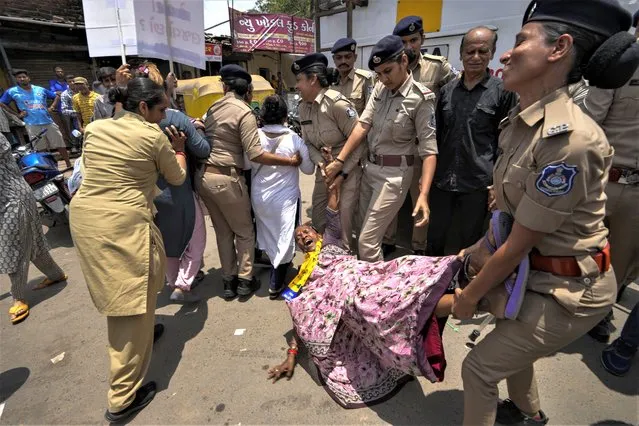 Police detains a supporter of Aam Aadmi Part (AAP) as they try rally in protest against the growing oppression of women in northeastern Manipur state and across the country, in Ahmedabad, India, Tuesday, July 25, 2023. Protests have erupted across the country after a video showing mob assaults on two women who were paraded naked sparked widespread outrage on social media. More than 130 people have been killed in the northeastern state since violence between two dominant ethnic groups erupted in early May. (Photo by Ajit Solanki/AP Photo)