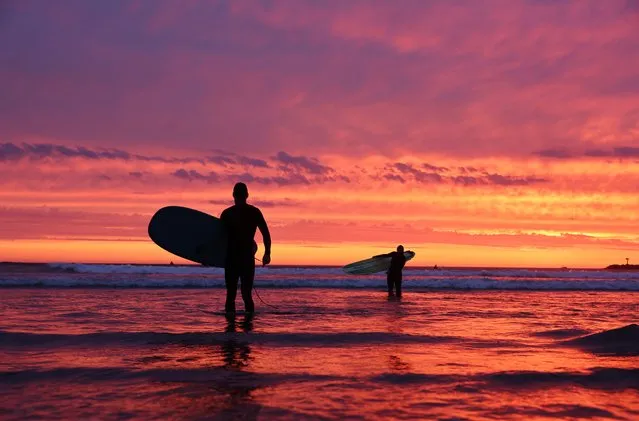 Surfers walk out of the Pacific Ocean at Ocean Beach shortly after sunset with Hurricane Hilary approaching on August 19, 2023 in San Diego, California. Southern California is under a first-ever tropical storm warning as Hurricane Hilary approaches with parts of California, Arizona and Nevada preparing for flooding and heavy rains. (Photo by Mario Tama/Getty Images)