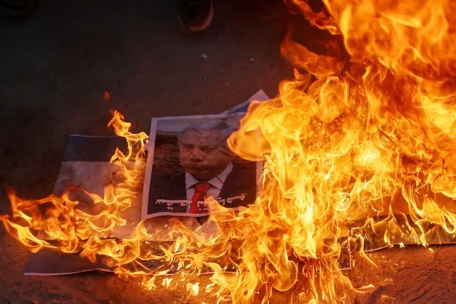 A picture depicting leader of Israeli Opposition Benjamin Netanyahu is burnt by Palestinians during a protest over a flag-waving procession by far-right Israeli groups in and around East Jerusalem's Old City, in the northern Gaza Strip on June 15, 2021. (Photo by Mohammed Salem/Reuters)