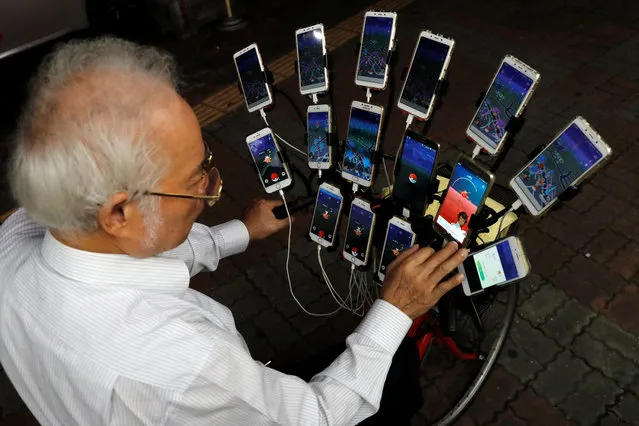 Taiwanese Chen San-yuan, 70, known as “Pokemon grandpa”, plays the mobile game “Pokemon Go” by Nintendo, near his home with 15 mobile phones, in New Taipei City, Taiwan November 12, 2018. (Photo by Tyrone Siu/Reuters)