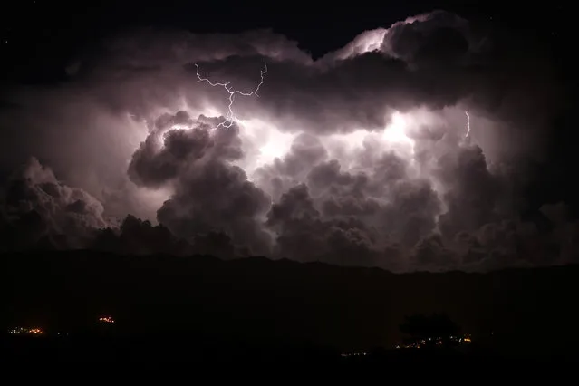A long exposure photograph shows a lightning during a storm over the Taravo valley and the Petreto-Bicchisano village on August 15, 2018 on the French Mediterranean Island of Corsica. (Photo by Pascal Pochard-Casabianca/AFP Photo)
