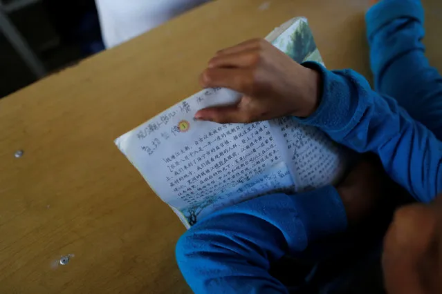 A child holds a book during a Chinese language lesson in a school at Namtit, Wa territory in northeast Myanmar November 30, 2016. Wa State is an unrecognised state in Myanmar (Burma) and is currently subsumed under the official Wa Special Region 2 of northern Shan State. The Wa were once known as the “Wild Wa” by the British due to their practice of headhunting. (Photo by Soe Zeya Tun/Reuters)