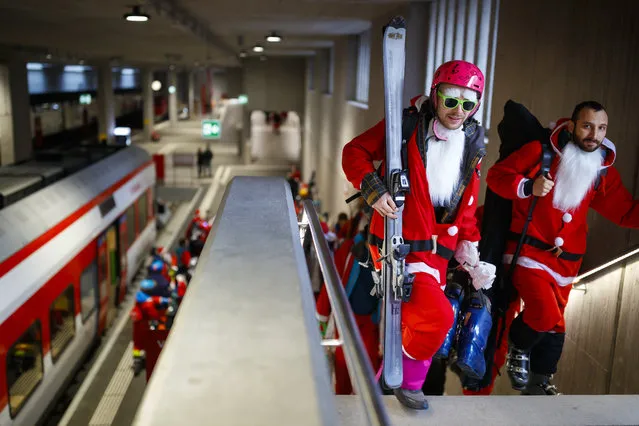 People dressed as Santa Claus carry their skis to take the ski lift to the alpine ski resort of Verbier, Saturday, December 8, 2018. 3015 skiers and snow boarders dressed as Santa Claus and Saint Nicholas were granted discounted 5 Swiss franc access pass to the ski resort as a promotional event to celebrate the opening of the ski season. (Photo by Valentin Flauraud/Keystone via AP Photo)
