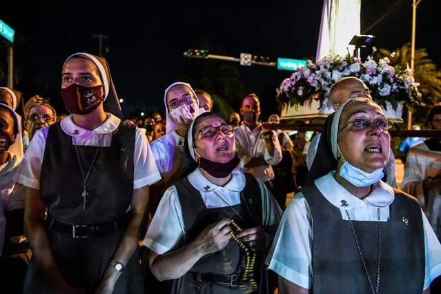 Nuns from the St. Joseph’s Catholic Church pray at the “Surfside Wall of Hope & Memorial” near the site of the collapsed building in Surfside, Florida, north of Miami Beach, on July 7, 2021. Florida rescuers have made the “extremely difficult decision” to end their search for survivors in the rubble of an apartment building which partially collapsed nearly two weeks ago, Miami-Dade county mayor Daniella Levine Cava said July 7. “It is with deep profound sadness . that we made the extremely difficult decision to transition from operation search and rescue to recovery”, Levine Cava told reporters in Surfside, near Miami, adding that the transition would formally take place at midnight. (Photo by Chandan Khanna/AFP Photo)