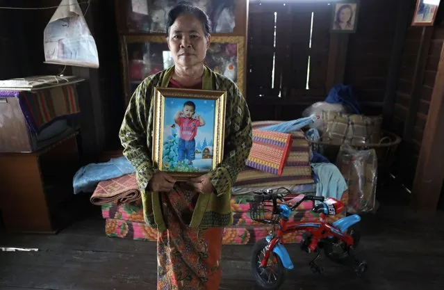 Aueang Chamnongnit holds a picture of her grandson 'Nong Captain' Phattharawat Chamnongnit, one of the children's care center mass shooting victims, at her home in Nong Bua Lamphu province, northeastern Thailand, 05 October 2023. Aueang Chamnongnit said 'It has been a year already. But it is hard to forget your grandson'. Families continue to mourn one year after a former police officer shot and stabbed 36 people, including 24 children, in a childcare center in northeast Thailand on 06 October 2022. (Photo by Narong Sangnak/EPA)
