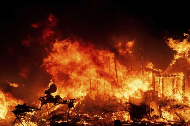 A structure is engulfed in flames as a wildfire called the Highland Fire burns in Aguanga, Calif., Monday, October 30, 2023. A wildfire fueled by gusty Santa Ana winds ripped through rural land southeast of Los Angeles on Monday, forcing thousands of people from their homes, fire authorities said. (Photo by Ethan Swope/AP Photo)
