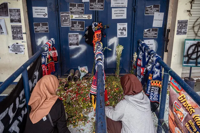 People pay their respects to the victims at Kanjuruhan stadium in Malang on October 7, 2022, following a stampede that killed at least 131 people in one of the deadliest disasters in football history. (Photo by Juni Kriswanto/AFP Photo)
