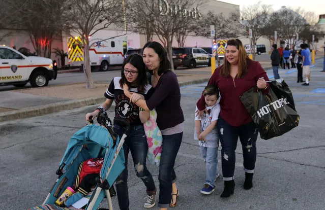 Shoppers with their children react after San Antonio police helped them exit the Rolling Oaks Mall after a deadly shooting Sunday, January 22, 2017, in San Antonio. Authorities say several were injured after a robbery at the shopping mall. (Photo by Eric Gay/AP Photo)