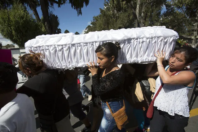 In this March 10, 2017 file photo, women carry the coffin of 17-year-old Siona Hernandez Garcia, a girl who died in a March 8, 2016 fire at the Virgin of the Assumption Safe Home, at the cemetery in Guatemala City. On Tuesday, Feb. 19, 2019, a Guatemalan judge ordered five current and ex-officials to stand trial over the blaze that killed 41 girls and injured 15 others at the state-run home for troubled youth. (Photo by Moises Castillo/AP Photo)