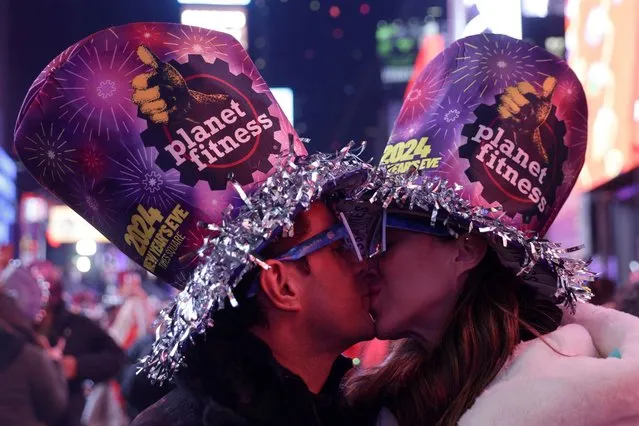 A couple kiss after the clock strikes midnight during New Year celebrations at Times Square, in New York City, New York, U.S., January 1, 2024. (Photo by Jeenah Moon/Reuters)