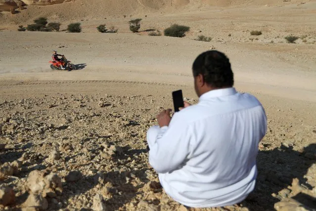 A spectator takes a photo of Red Bull KTM Factory's Toby Price during stage 4 in Saudi Arabia on January 9, 2024. (Photo by Hamad I Mohammed/Reuters)