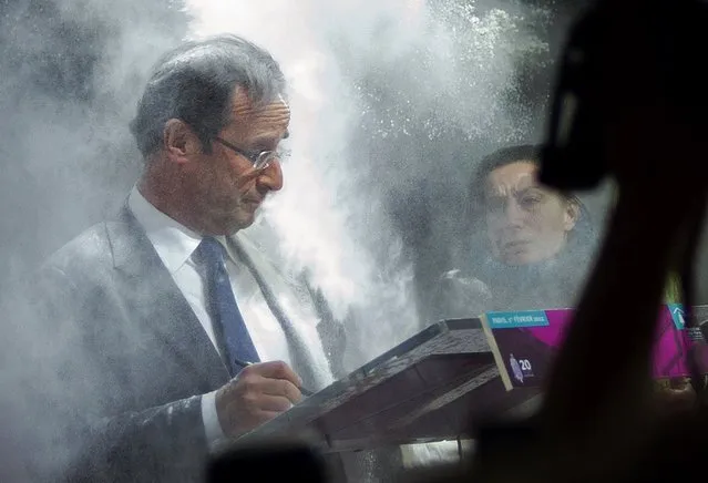 France's opposition Socialist Party (PS) candidate for the 2012 French presidential election Francois Hollande (C) receives flour, thrown by a woman (R) while he was signing a pact on French housing crisis with representatives of the Abbé Pierre Foundation on February 1, 2012 in Paris. (Photo by Fred Dufour/AFP Photo)