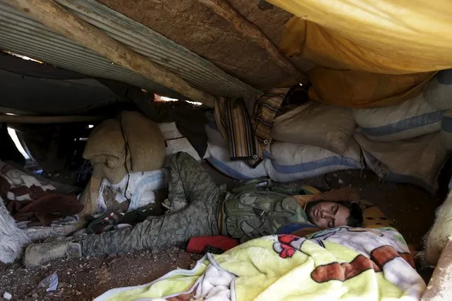 A rebel fighter from “Jaysh al-Sunna” sleeps inside a bunker in Tel Mamo village, in the southern countryside of Aleppo, Syria March 6, 2016. (Photo by Khalil Ashawi/Reuters)