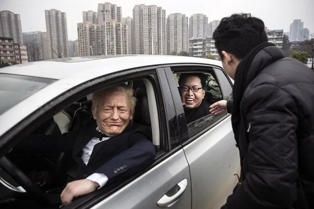 Sculptural artist Zhangzhen 33 with models wearing his masks of US President Donald Trump and Supreme Leader of North Korea Kim Jong-un seen on February 20, 2019 in Wuhan, China. The second Trump-Kim summit is to be held in Vietnam by the end of February 2019. (Photo by Wang He/Getty Images)