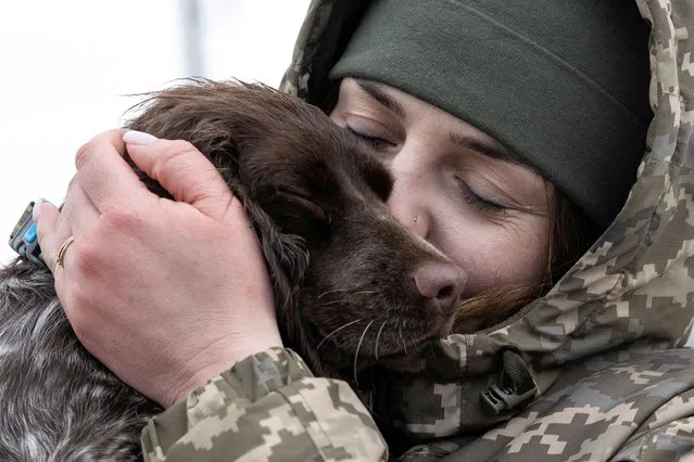 Alina Panina, 27-year-old, Ukrainian border guard member and former prisoner of war (POW), embraces her service dog “Roksi”, amid Russia's attack on Ukraine, in the town of Novovolynsk, Volyn region, Ukraine on January 23, 2024. (Photo by Valentyn Ogirenko/Reuters)