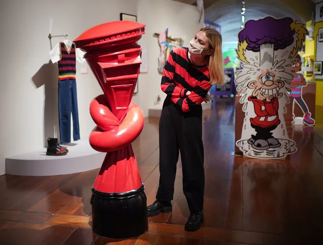 A staff member poses next to a red postbox artwork by Alex Chinneck, at The Beano: The Art of Breaking the Rules, an exhibition of the world’s longest-running weekly comic at Somerset House in London, United Kingdom on October 20, 2021. (Photo by Yui Mok/PA Wire Press Association)
