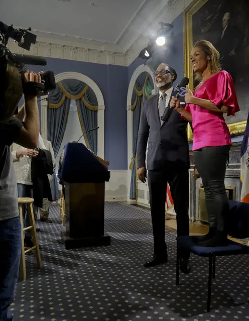 Reporter Kimberly Richardson stands on a chair to interview New York City Councilman Robert Cornegy, Jr., after he was awarded the Guinness World Record's for tallest male politician, Wednesday March 27, 2019, at City Hall in New York. (Photo by Bebeto Matthews/AP Photo)
