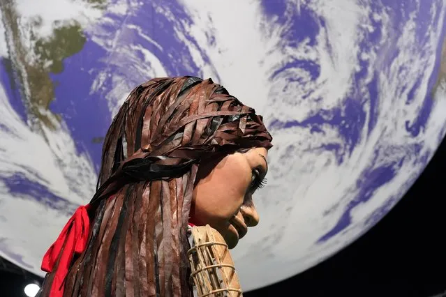 Giant puppet Little Amal walks through the Action Zone inside the venue of the COP26 U.N. Climate Summit in Glasgow, Scotland, Tuesday, November 9, 2021. (Photo by Alberto Pezzali/AP Photo)
