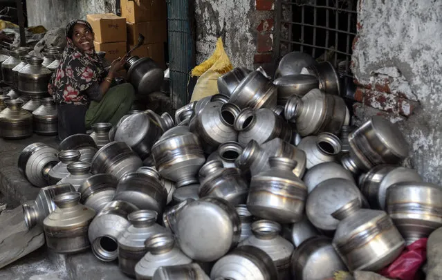 An Indian worker polishes kitchenware water pots at a local stainless steel manufacturing unit on the eve of International Labour Day in Mumbai, India, 30 April 2015. Labour Day, or May Day, is observed all over the world on the first day of May to celebrate the economic and social achievements of workers and the fight for labourers' rights. (Photo by Divyakant Solanki/EPA)