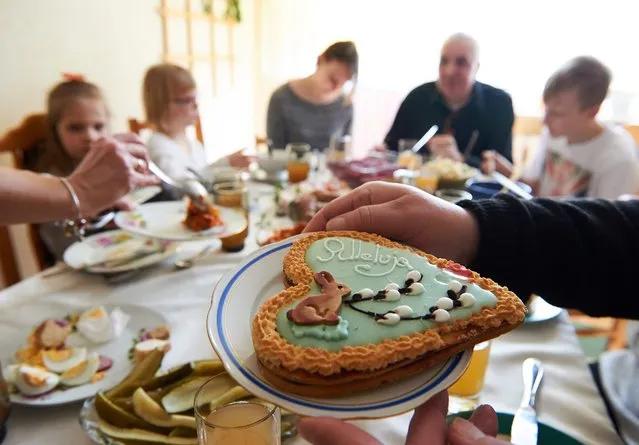Polish family during the traditional breakfast on Easter Sunday in Elblag, Poland, 27 March 2016. Easter is a Christian celebration commemorating the resurrection of Jesus Christ. (Photo by Adam Warzawa/EPA)