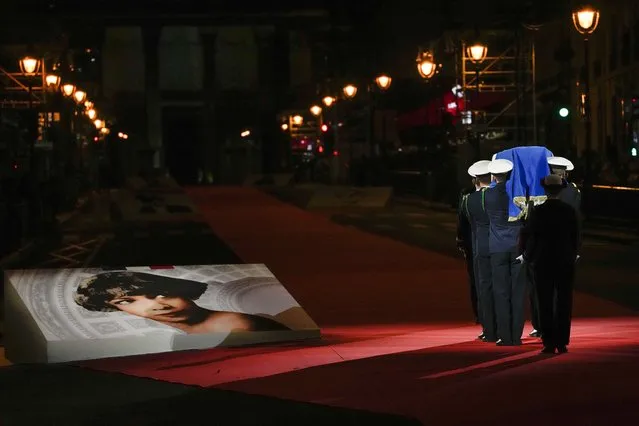 Pictures of Josephine Baker adorn the red carpet as the coffin with soils from the U.S., France and Monaco is carried towards the Pantheon monument in Paris, France, Tuesday, November 30, 2021, where Baker is to symbolically be inducted, becoming the first Black woman to receive France's highest honor. Her body will stay in Monaco at the request of her family. (Photo by Christophe Ena/AP Photo)
