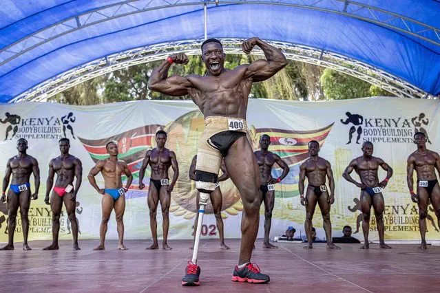 Tamale Safaulu, 28, poses on stage during the Mr.001 bodybuilding competition in Mombasa, Kenya, on December 11, 2021. Tamale is a Ugandan bodybuilder who has been competing since 2015. In February 2020 he lost his leg in a motorcycle accident but a year later he was able to win Mr. Kampala in the “persons with disabilities” category. Mr.001 is his first bodybuilding event outside of Uganda. (Photo by Patrick Meinhardt/AFP Photo)