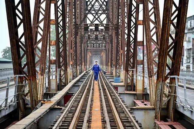 A worker walks in the middle of the track during railway track maintenance work on the Long Bien bridge in Hanoi on February 20, 2024. (Photo by Nhac Nguyen/AFP Photo)