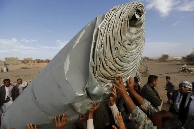 People carry part of a Saudi fighter jet found in Bani Harith district north of Yemen's capital Sanaa May 24, 2015. (Photo by Khaled Abdullah/Reuters)