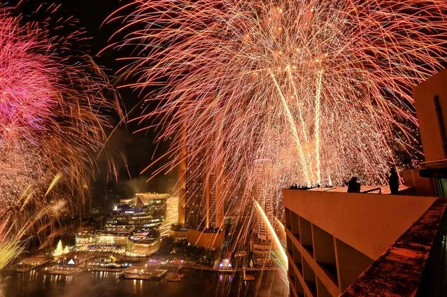 New Year's Eve fireworks erupt over the Chao Praya River in Bangkok on December 31, 2021. (Photo by Lillian Suwanrumpha/AFP Photo)