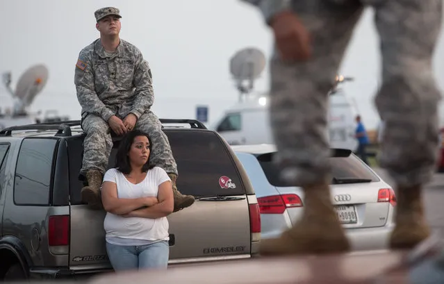 Lucy Hamlin and her husband, Spc. Timothy Hamlin, wait for permission to re-enter the Fort Hood military base, where they live, following a shooting on base on Wednesday, April 2, 2014, in Fort Hood, Texas. One person was killed and 14 injured in the shooting, and officials at the base said the shooter is believed to be dead. (Photo by Tamir Kalifa/AP Photo)