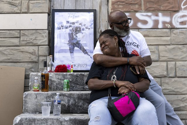 Antonio Lee's mother is comforted while mourning her son at a vigil, Friday, Aug. 18, 2023, in Baltimore. Lee, 19, was shot and killed while squeegeeing in Baltimore. Lee and childhood friend Antonio Moore grew up together in the streets of east Baltimore, surrounded by poverty and gun violence. But only one would make it out alive. Moore is a successful real estate investor and marketing consultant. Lee was shot and killed last summer, four months before his 20th birthday. (Photo by Julia Nikhinson/AP Photo)