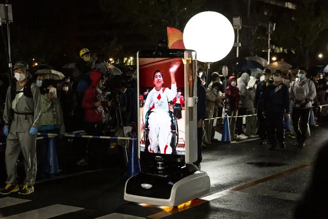 A virtual mobility robot  showing a torch bearer runs with the Olympic flame during the Tokyo Olympic Games Torch Relay on April 06, 2021 in Toyota, Aichi, Japan. (Photo by Yuichi Yamazaki/Getty Images)