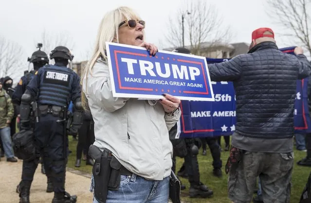 Supporter KT Layton of Bonney Lake, Washington sings the U.S. national anthem to end a March 4 Trump  rally on March 4, 2017 in Olympia, Washington. At the mostly peaceful rally for U.S. President Donald Trump, officials estimated there were approximately 200 supporters and 125 protesters. (Photo by Stephen Brashear/Getty Images)
