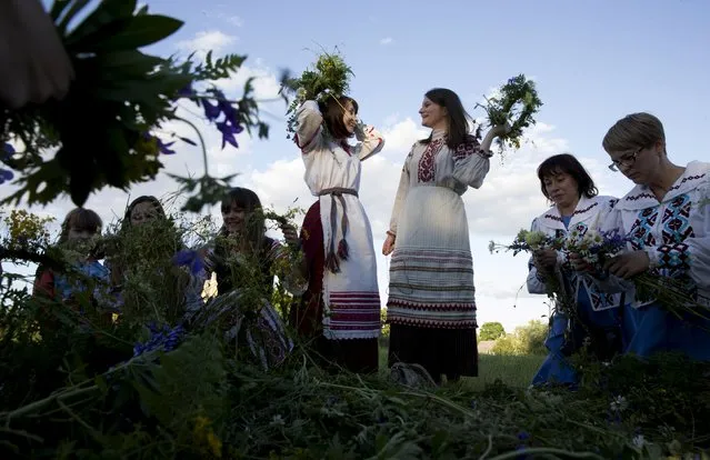 Belarusian women and girls make wreaths as they take part in the Ivan Kupala festival near the town of Rakov, west of Minsk June 27, 2015. (Photo by Vasily Fedosenko/Reuters)