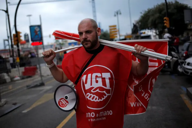 A member of the General Workers Union (UGT) carries flags as he takes part in a May Day rally in Malaga, Spain, May 1, 2016. (Photo by Jon Nazca/Reuters)