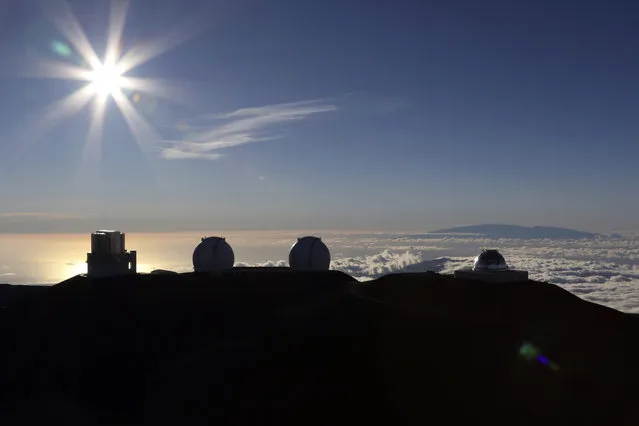 In this Sunday, July 14, 2019, file photo, the sun sets behind telescopes at the summit of Mauna Kea in Hawaii. The man tasked with trying to find a way out of an impasse over the construction of a giant telescope in Hawaii says he met with Native Hawaiian leaders. But the only issue they reached a consensus on was to meet again. (Photo by Caleb Jones/AP Photo/File)