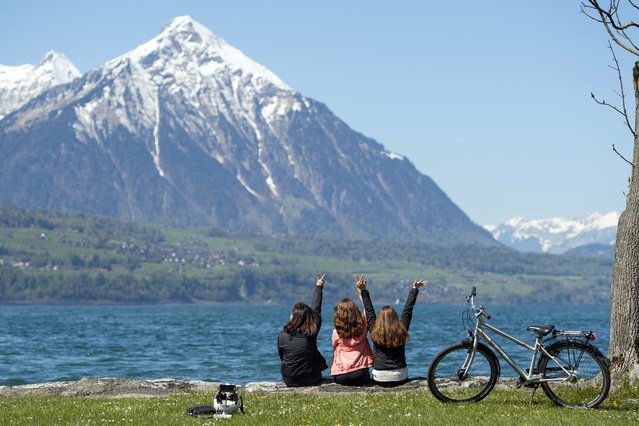 People enjoy the sunny weather in front of the Niesen mountain in Neuhaus near Interlaken, Switzerland, 05 May 2016. (Photo by Peter Schneider/EPA)