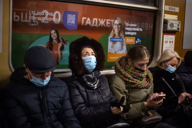 Passengers wear protective face masks while travelling on a metro train in Kyiv, Ukraine, on Tuesday, February 15, 2022. Washington and its allies have threatened sweeping sanctions if Vladimir Putin takes action against Ukraine – the U.S. has said its intelligence indicates Russia may attack imminently, officials in Moscow have repeatedly denied an invasion is planned. (Photo by Ethan Swope/Bloomberg)